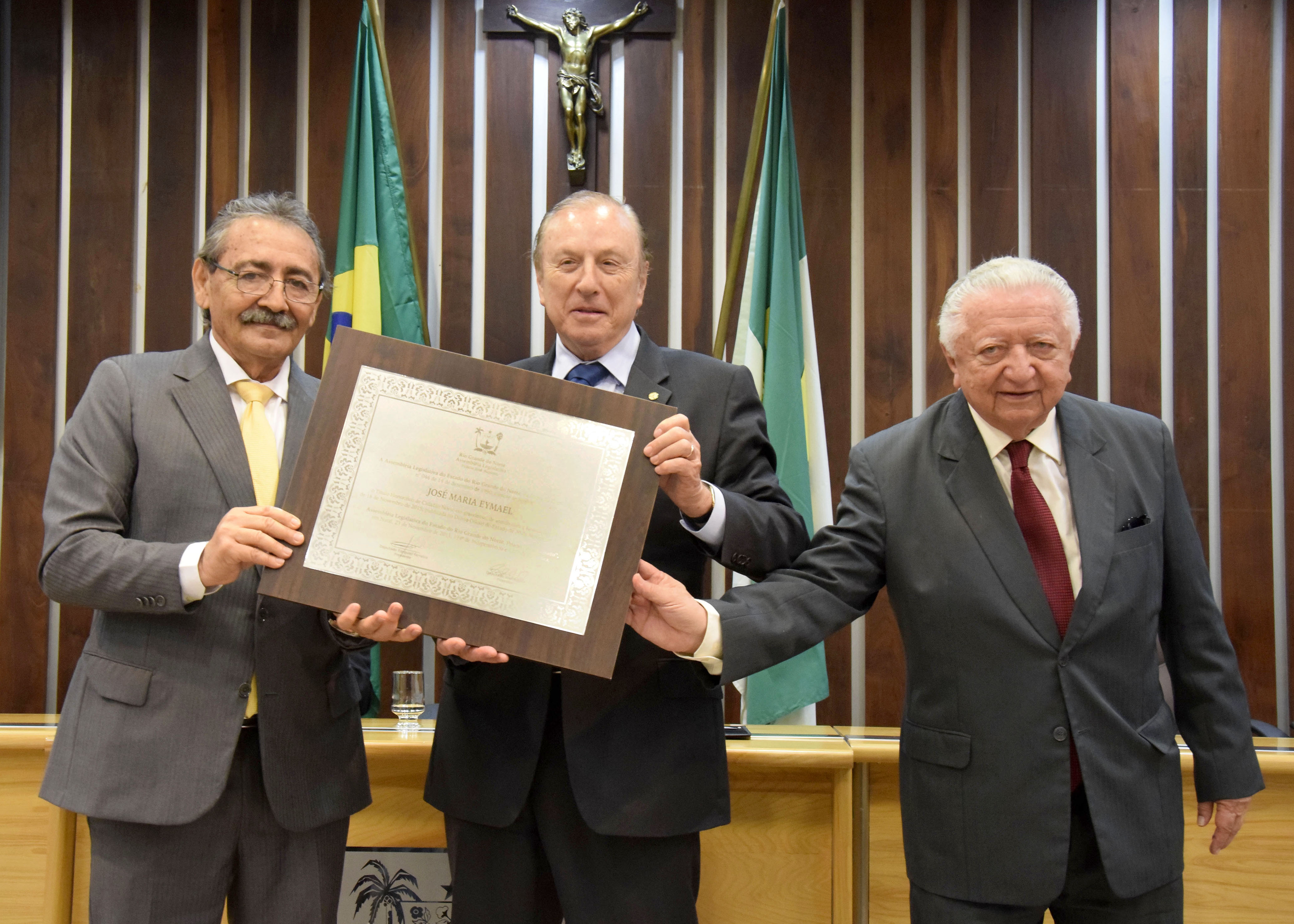 Eymael recebendo o títulos nas mãos do deputado José Adécio e do vereador Joanilson de Paula Rêgo (Foto: ALRN)